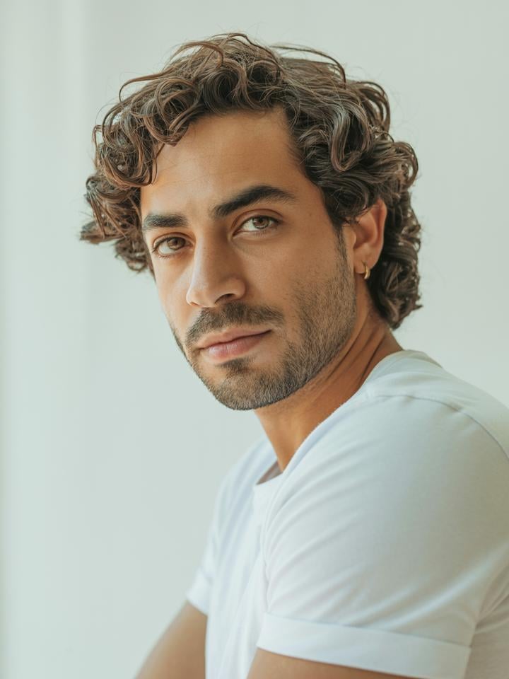 Marco — AI fashion model: Curly brown hair, gold earring, Mediterranean warmth